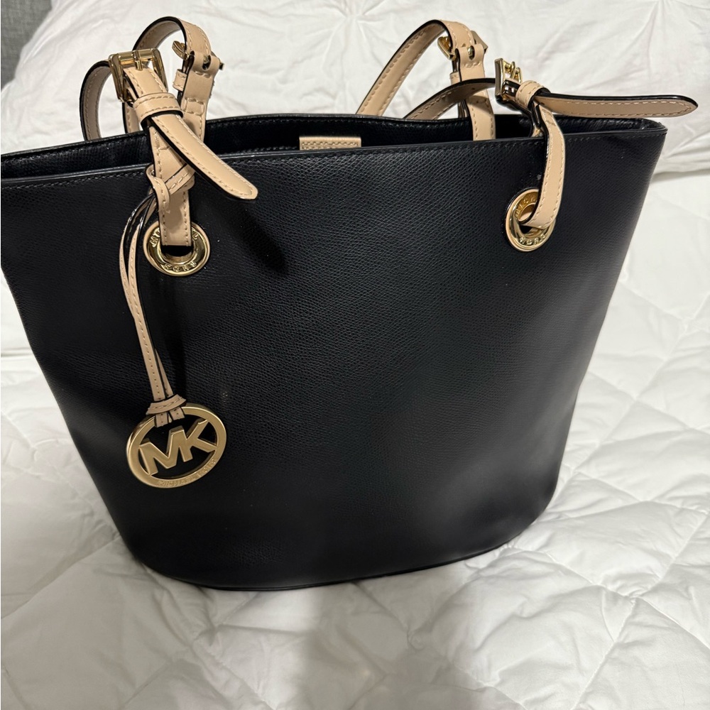Black MK purse with tan straps. Outside pocket inside pockets.
